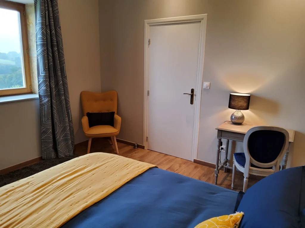 Bureau en bois placé devant la fenêtre de la chambre Tilia