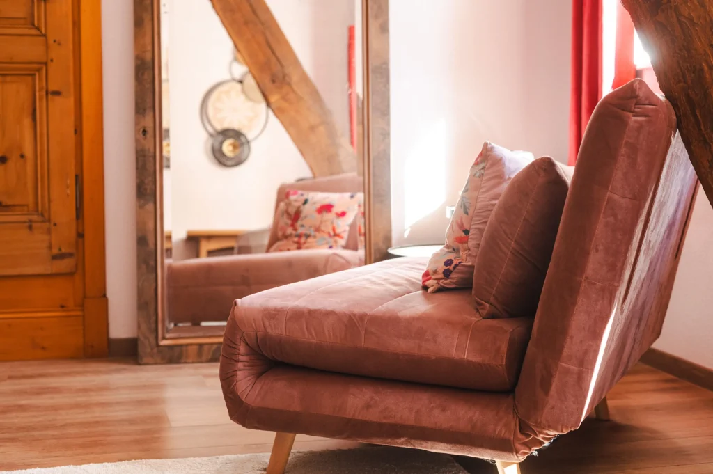 Fauteuil en velours rose et miroir rond de la chambre Prunus